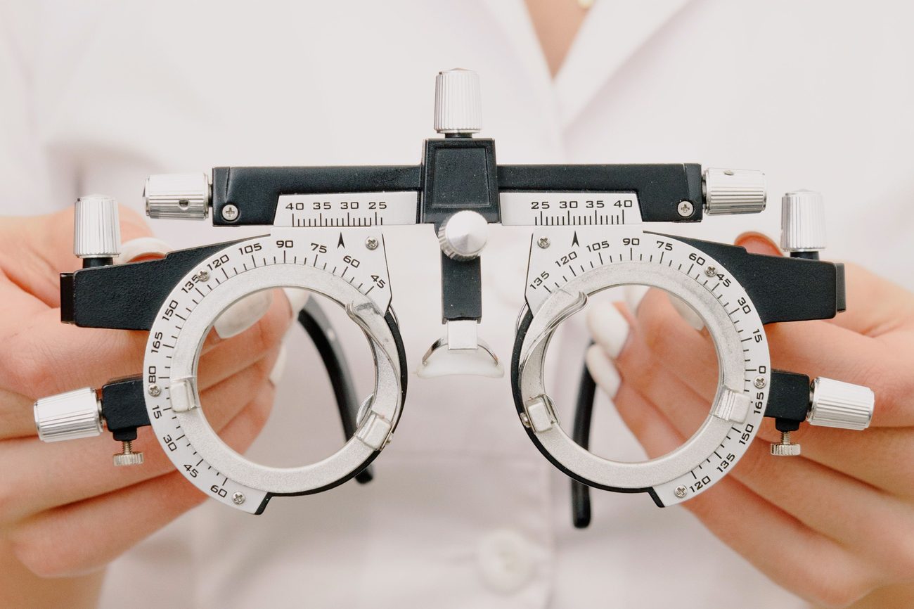 An optometrist holding a trial frame used for eye exams