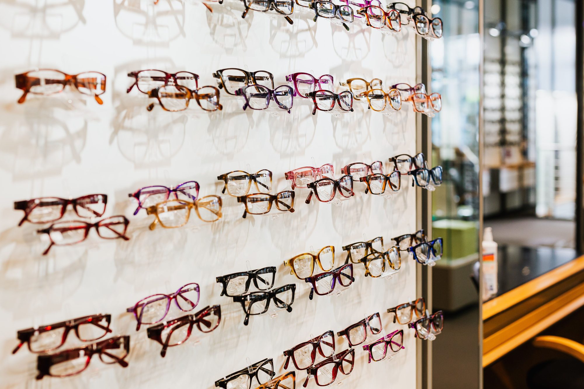Rows of eyeglass frames displayed on the wall of an optical shop